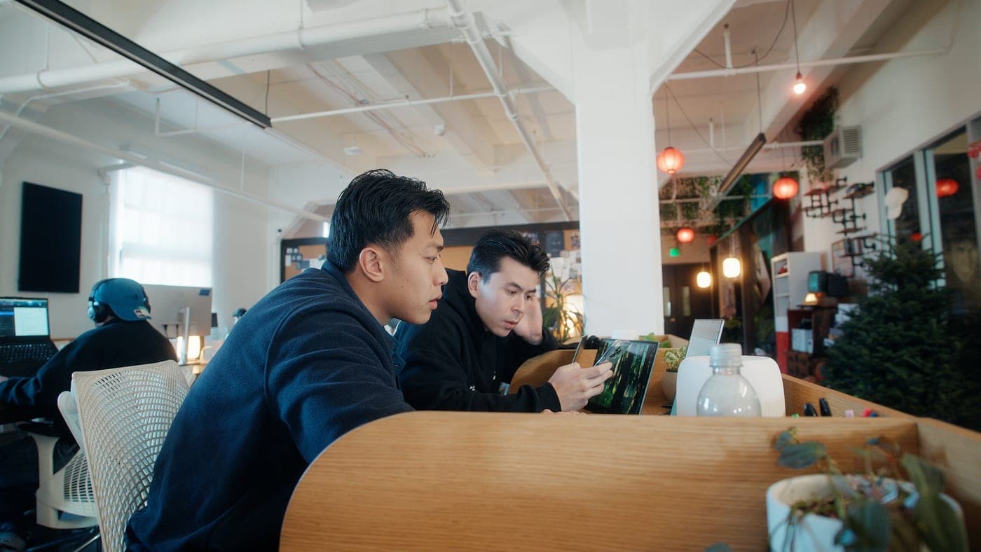 Will and a teammate looking over a laptop at Founders Inc