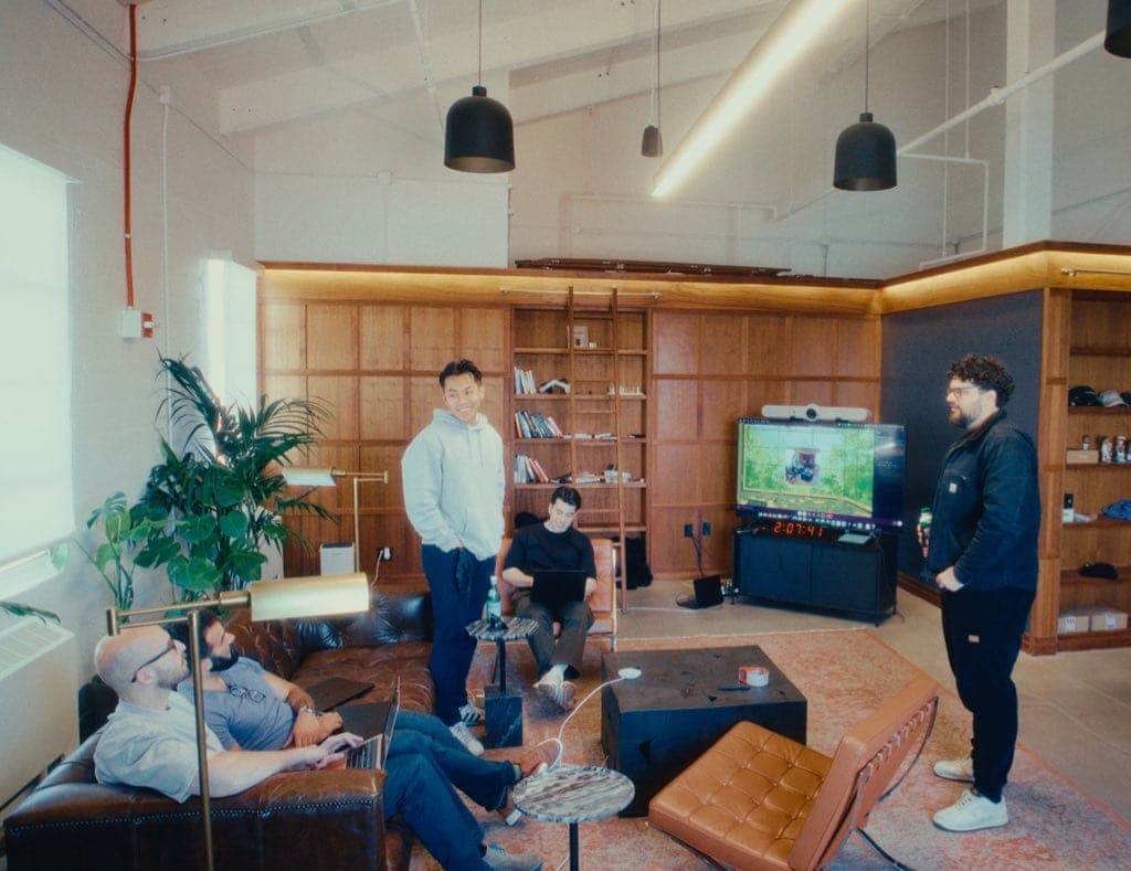 Will at office hours, standing in a lounge with other founders